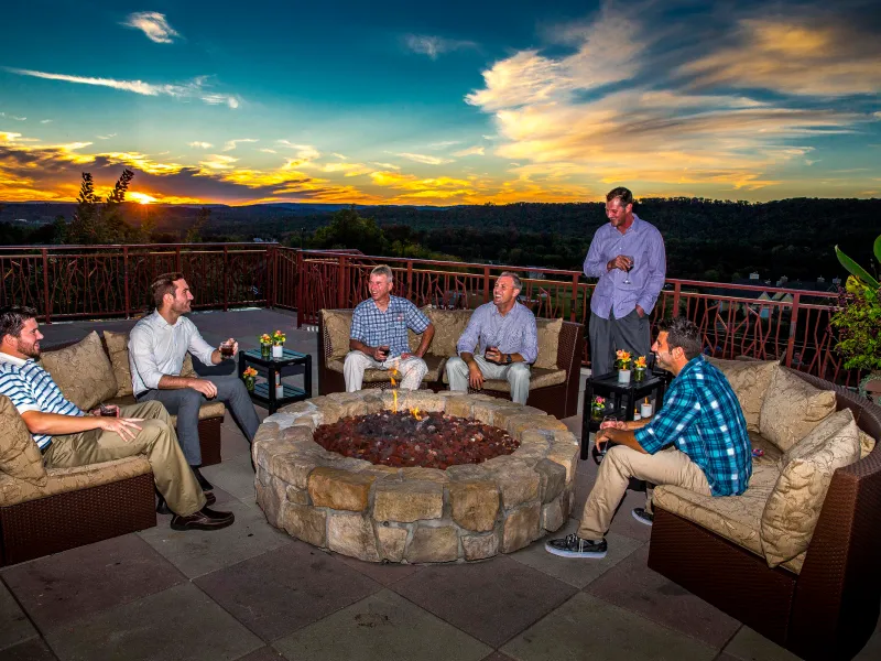 Group of guys sitting by a fire pit on the Fire and Water Terrace