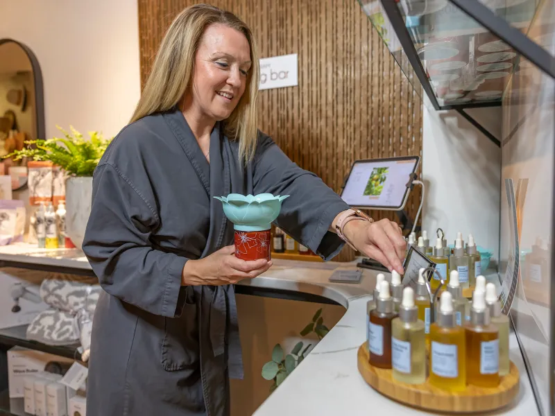 Woman creating a custom blend of oils at the Elements blend bar.